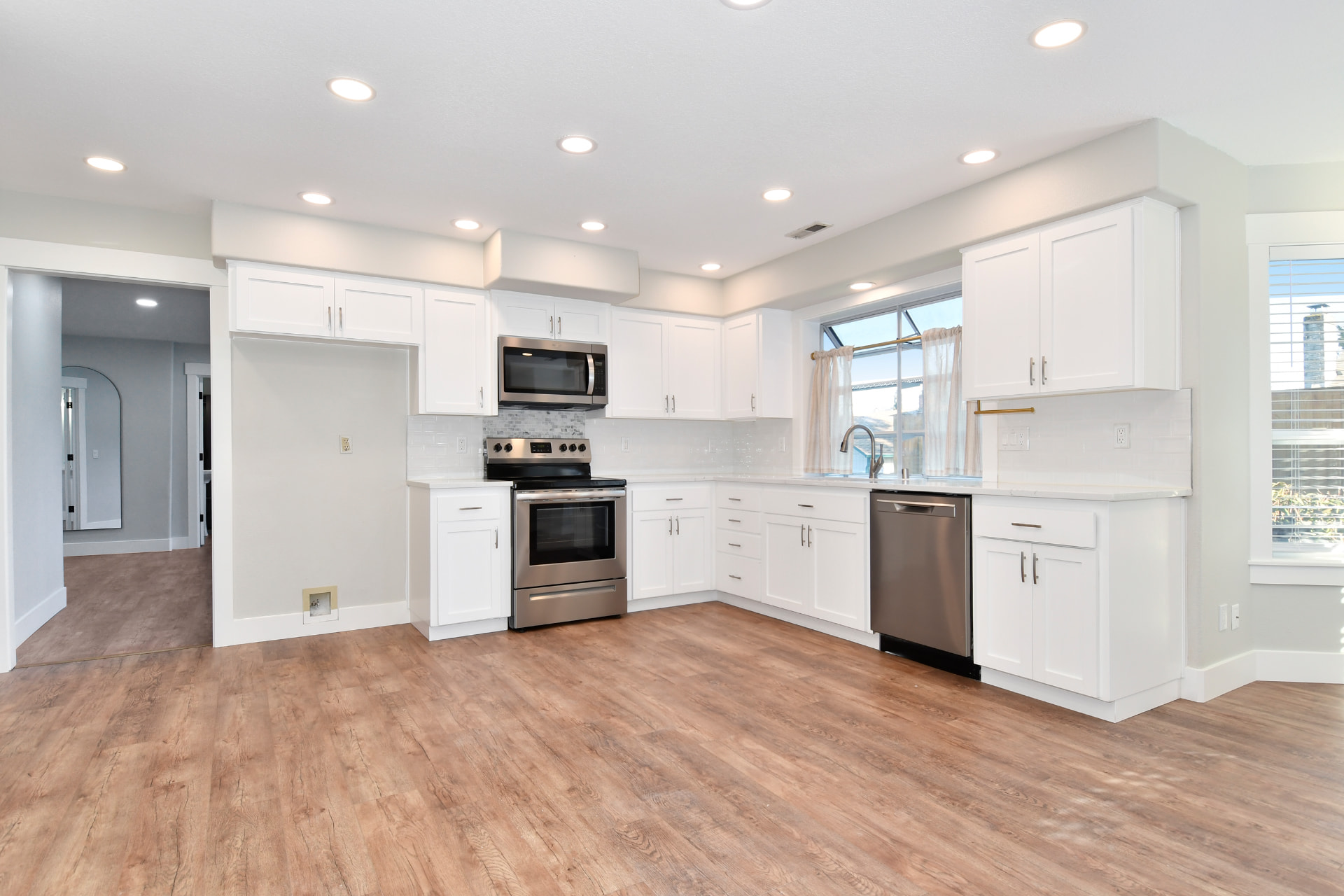 Kitchen cabinets after being sprayed bright white by Happy Walls Painting Company
